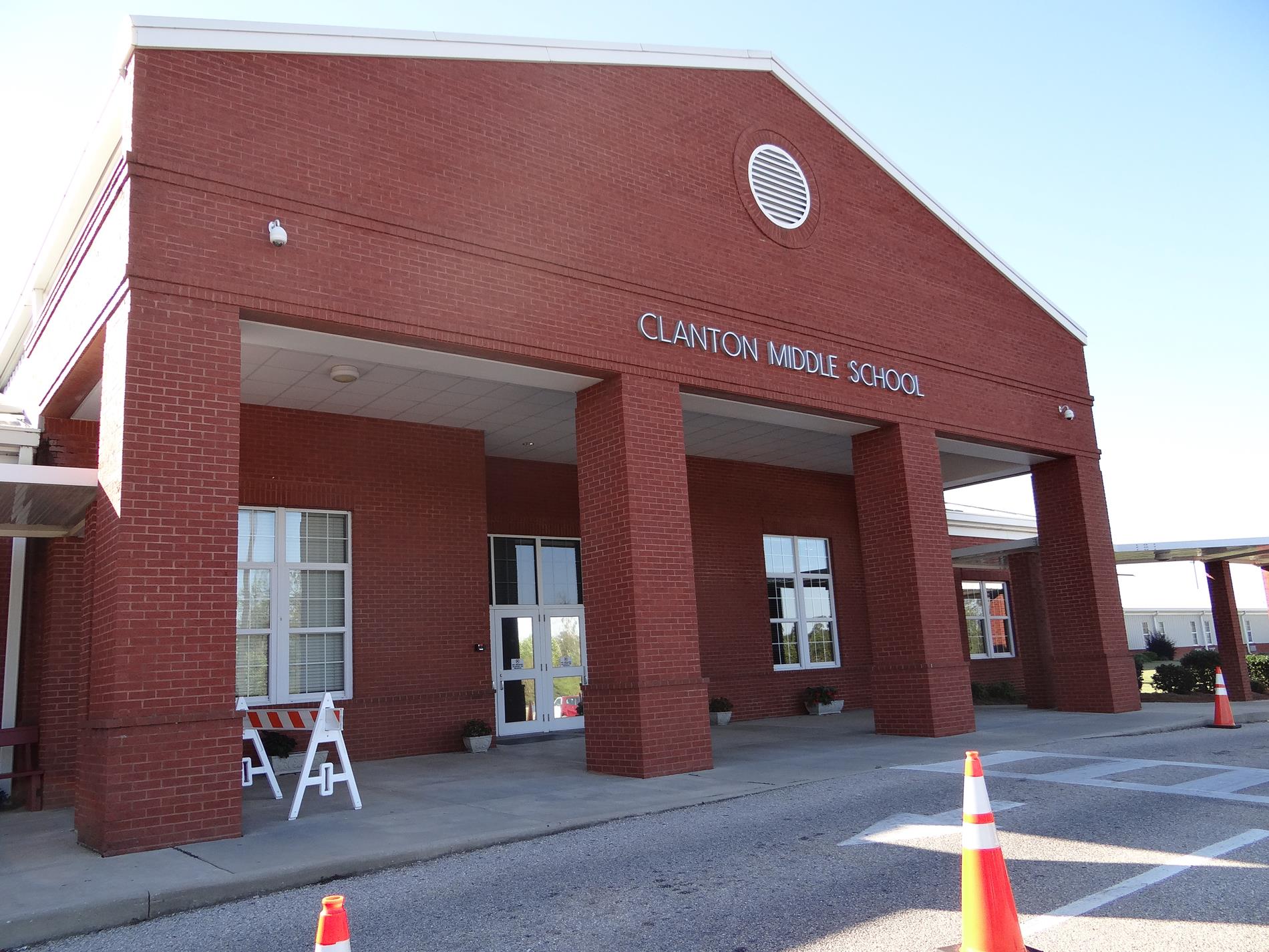 Angled View of the Front Entrance of Clanton Middle School - A red-brick school building with four tall brick columns framing the front doors