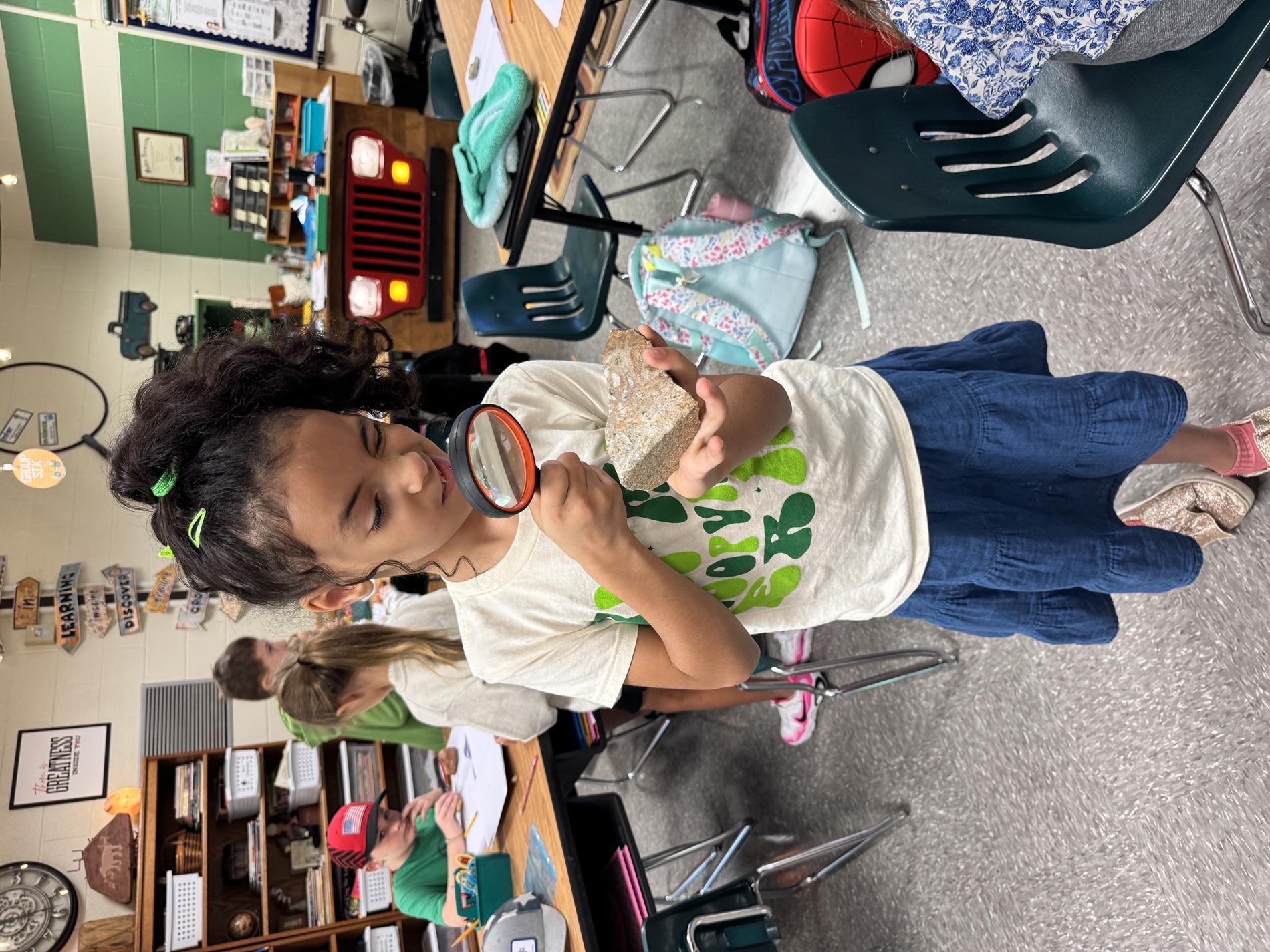 Student looking through magnifying glass