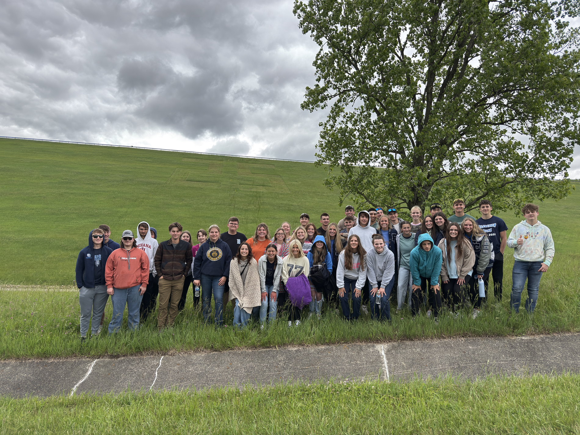 FCHS Seniors standing in front of the "25" inscribed on the face of Brookville Dam to show their hard work 