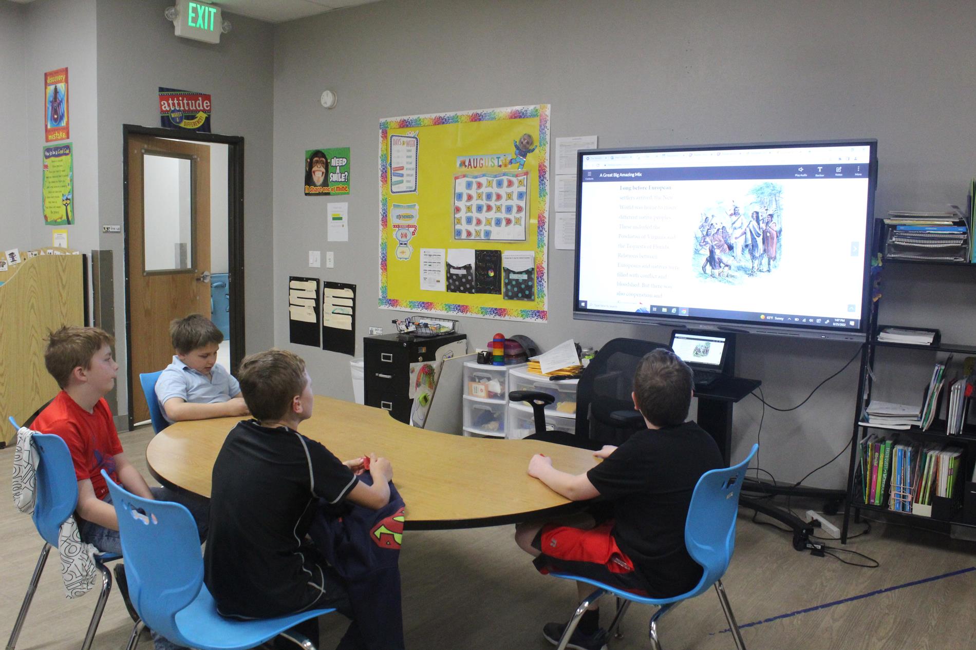 Students reading from a television monitor