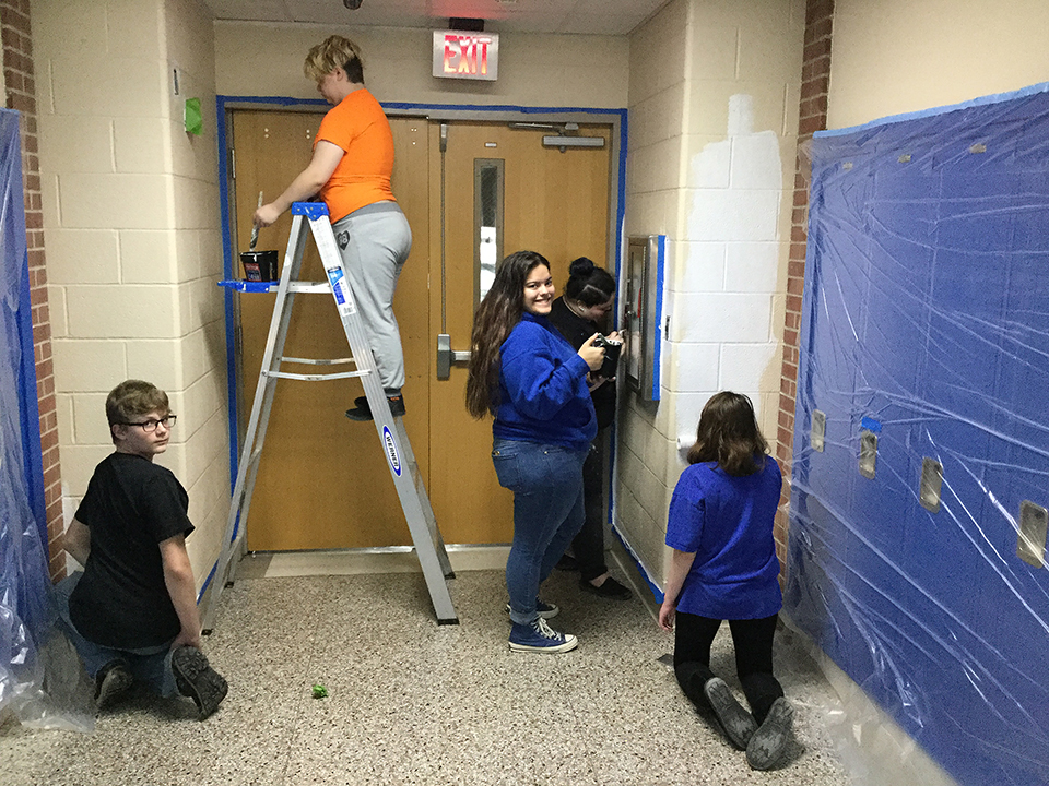 Students volunteering to help paint
