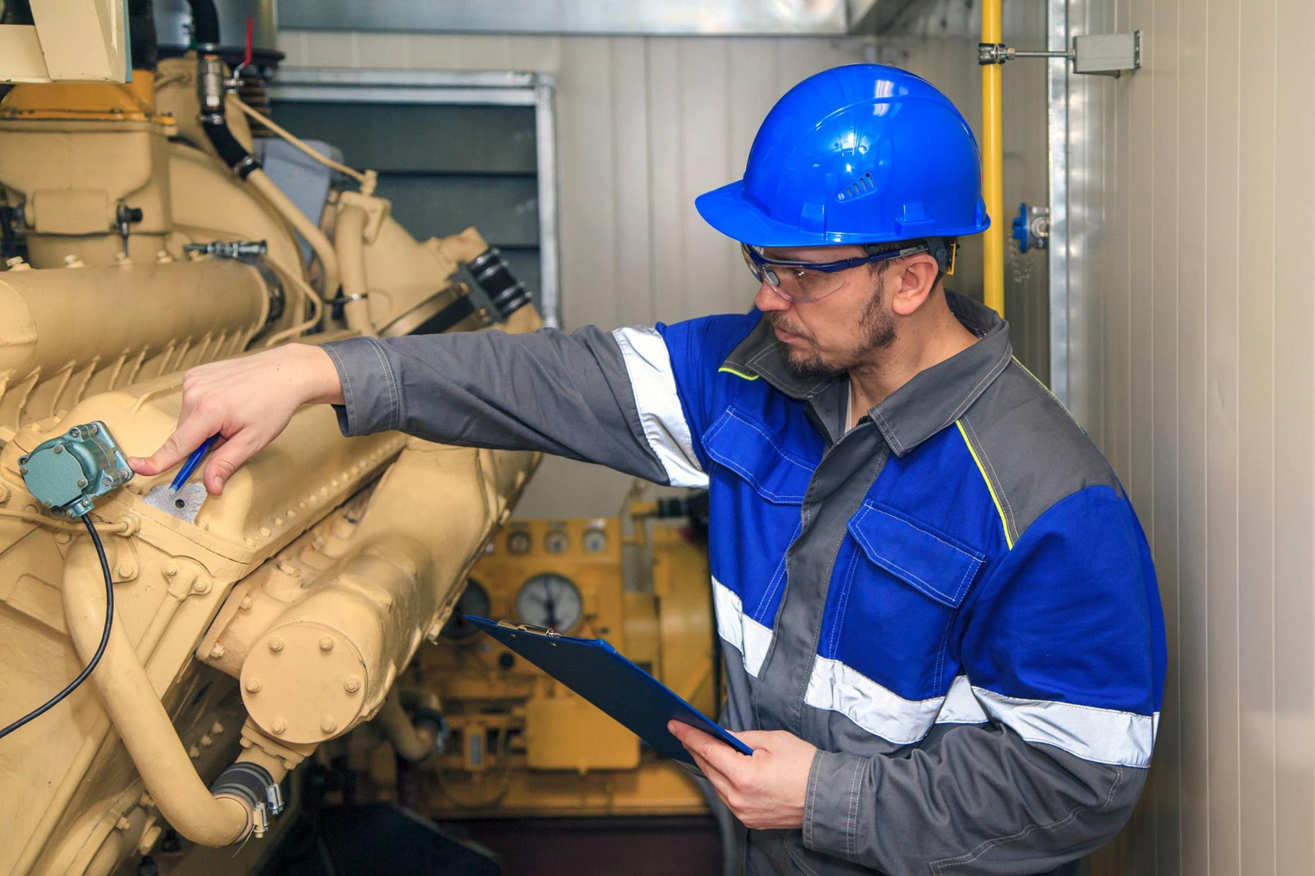 A technician inspecting a diesel engine.