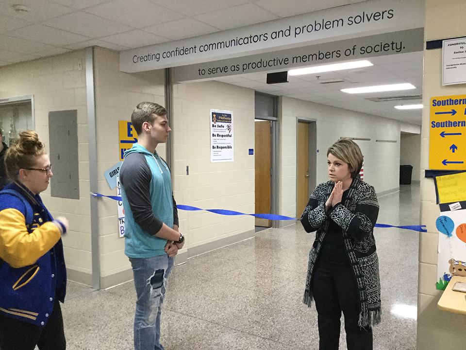 cutting the ribbon, senior Victor Duncan and Ms. Adams