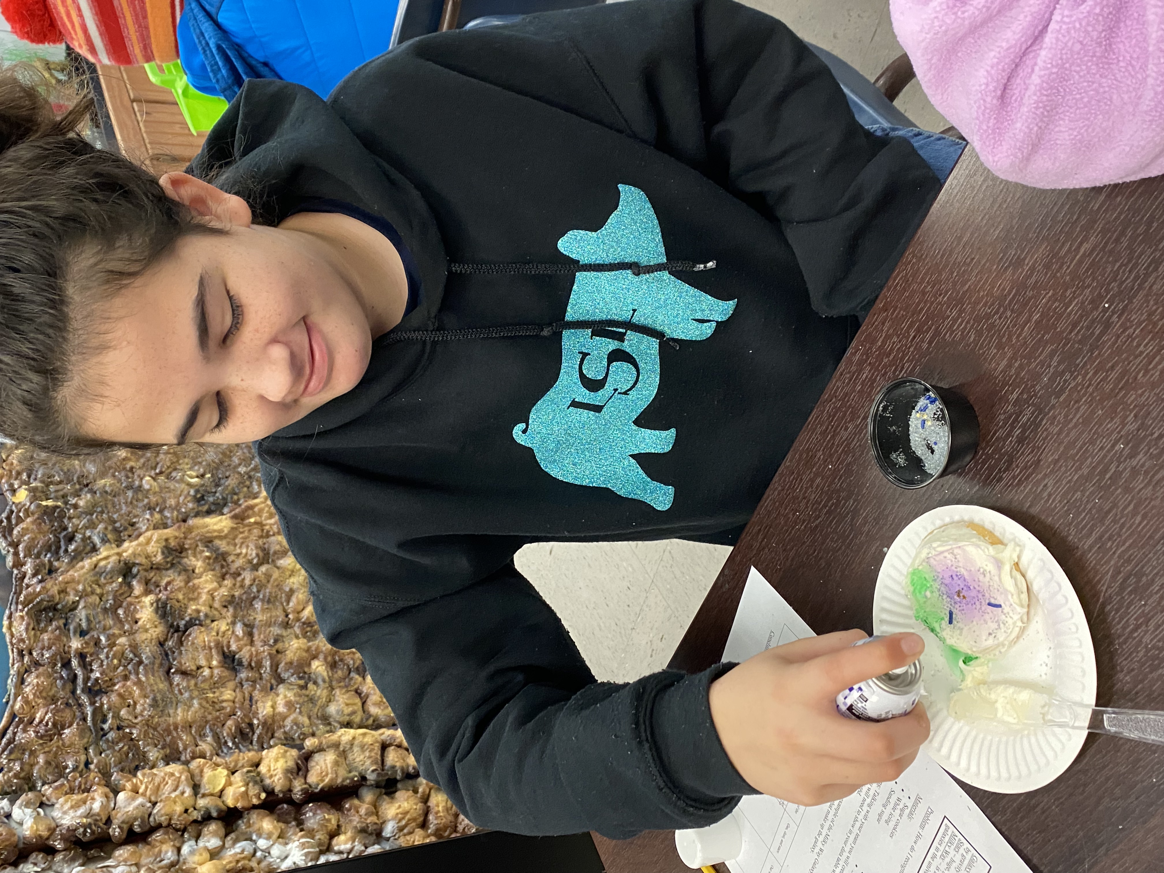 A student adding their gas to their spiral galaxy cookie. 