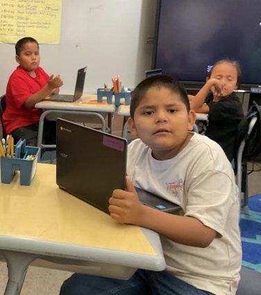 A second grade student working on a Chromebook