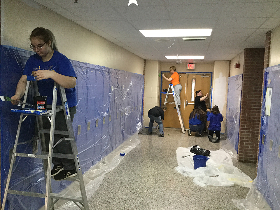 Students volunteering to help paint