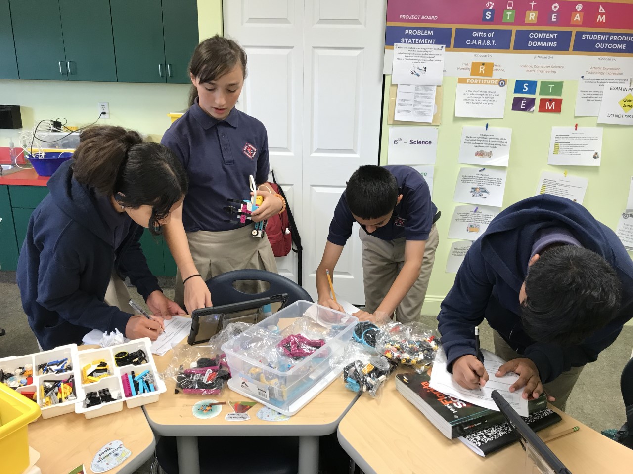Kristamarie, Adriana, Miguel, and Jose work together to code their robotic hand. 