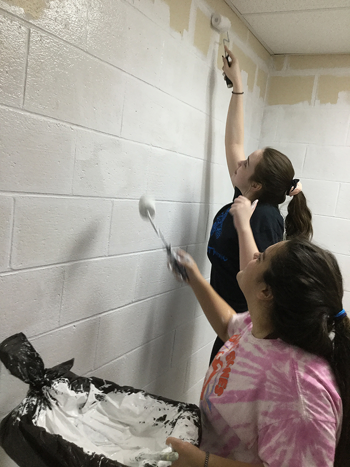 Students volunteering to help paint