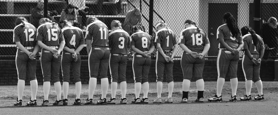 softball team praying before game