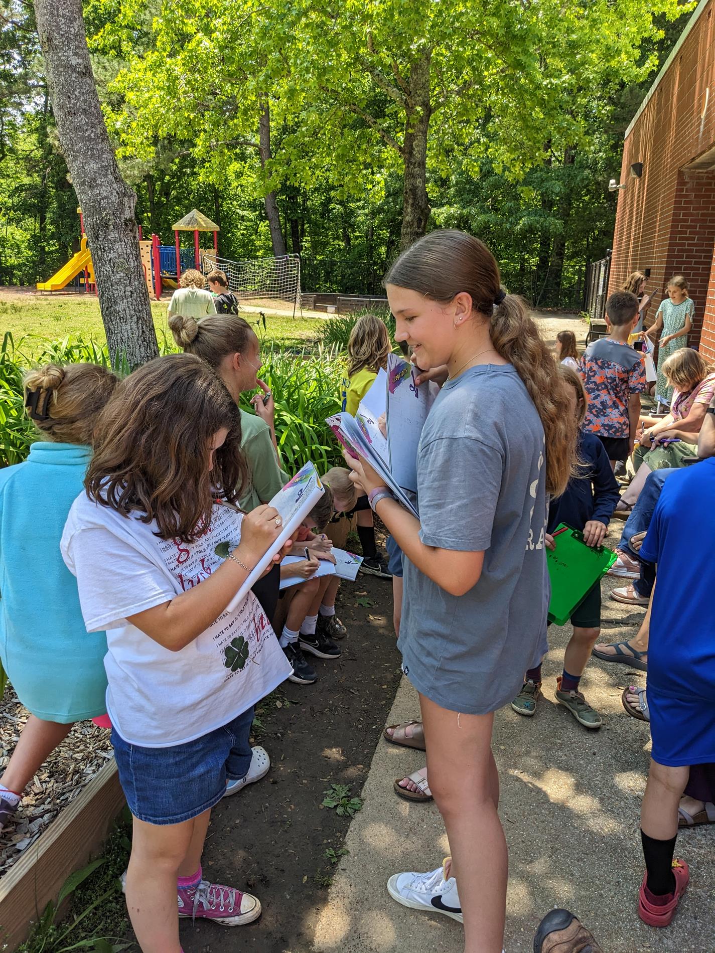 elementary school students signing yearbooks