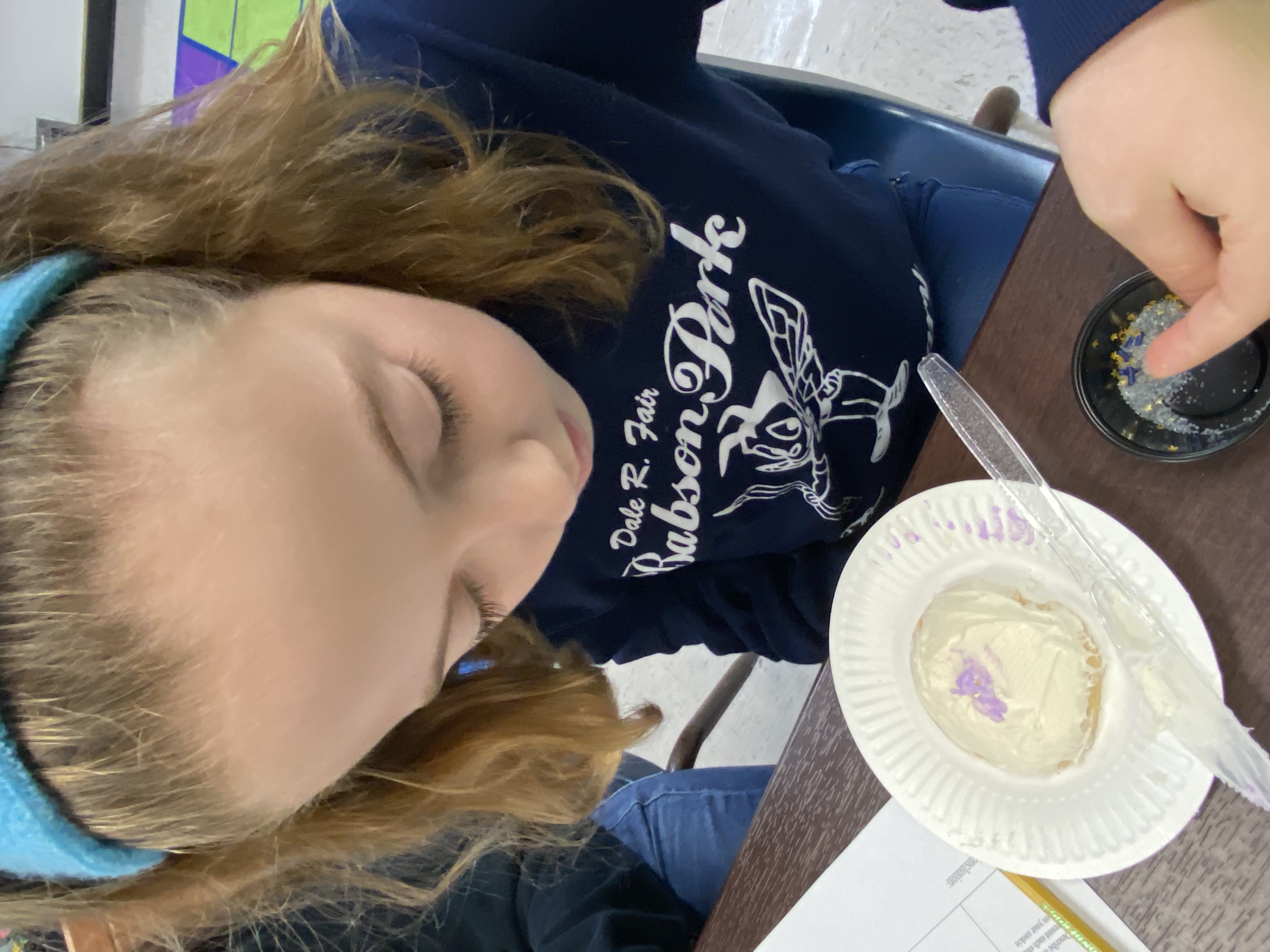 5th grade student placing stars on her galaxy cookie.