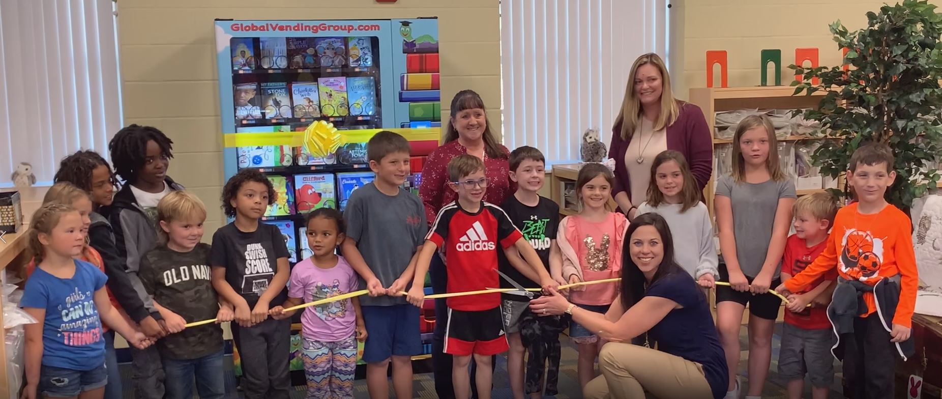 Students and staff cutting a ribbon