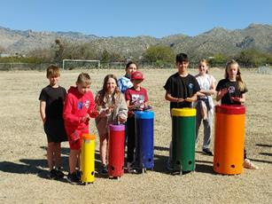 Students playing rainbow sambas in outdoor Music Garden