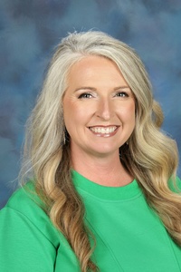 Teacher smiling against a blue background