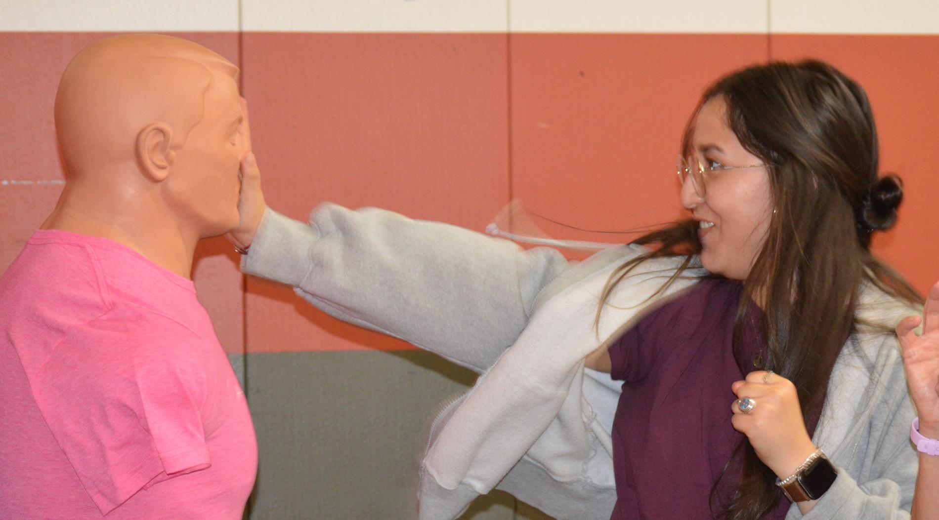 Picture of Victoria practicing self defense moves on a dummy 