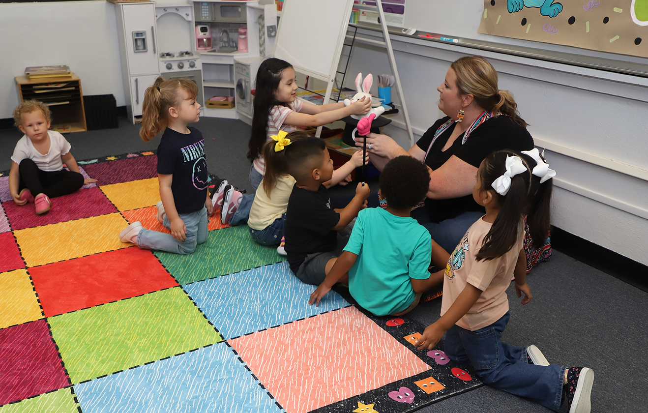 Students with teacher sitting on floor