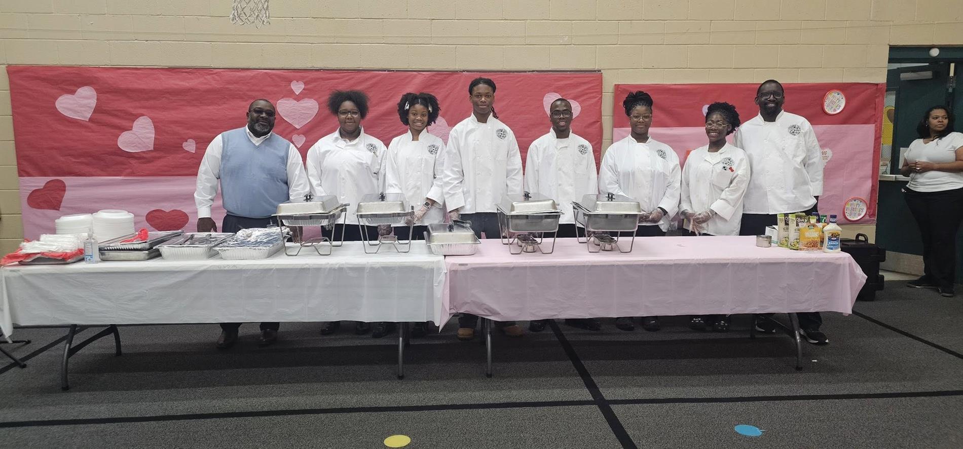 people standing in a row behind a table