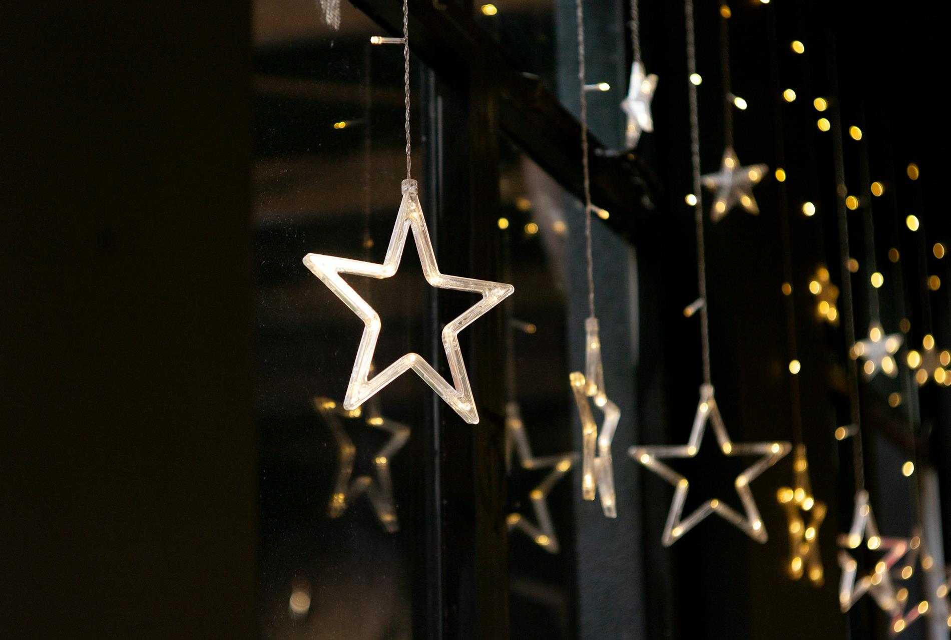 Lighted star decorations hang in front of a black backdrop
