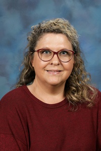 Teacher smiling against a blue background