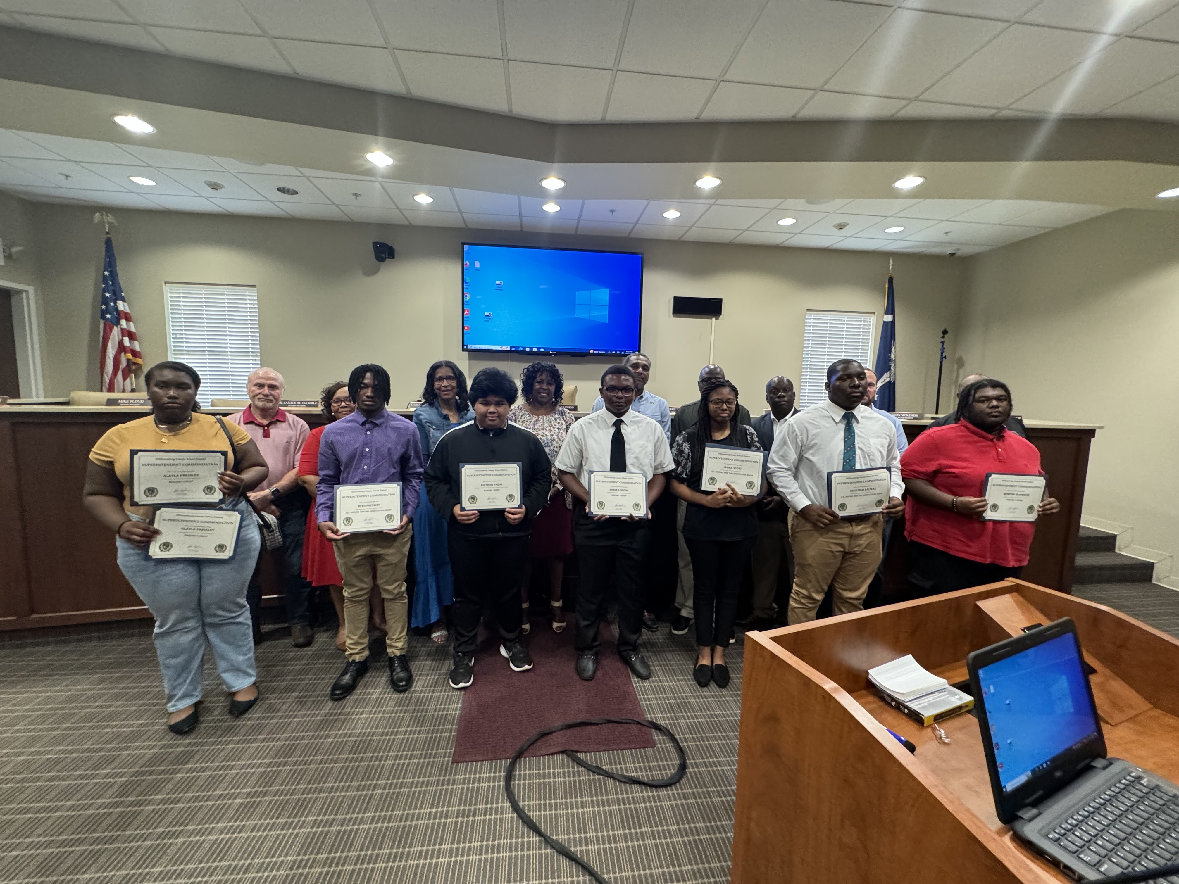 Students being recognized for their academic achievement pictured along with school board members 