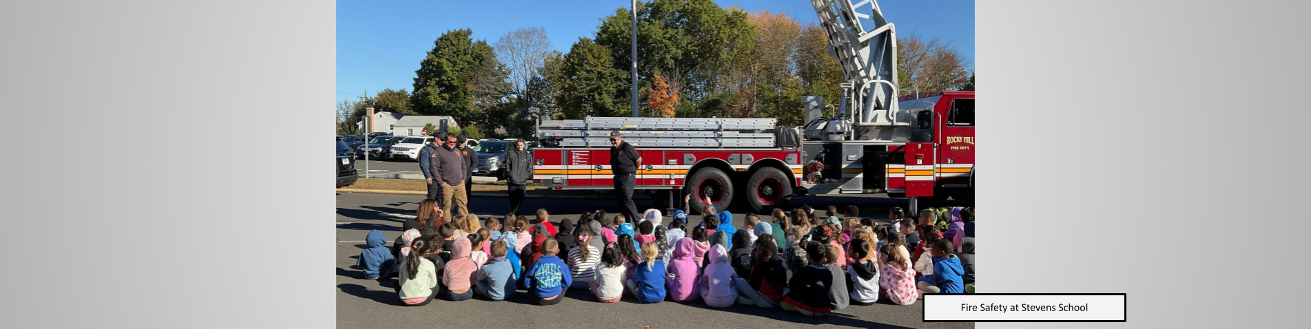 Students listening to a fire safety presentation outside