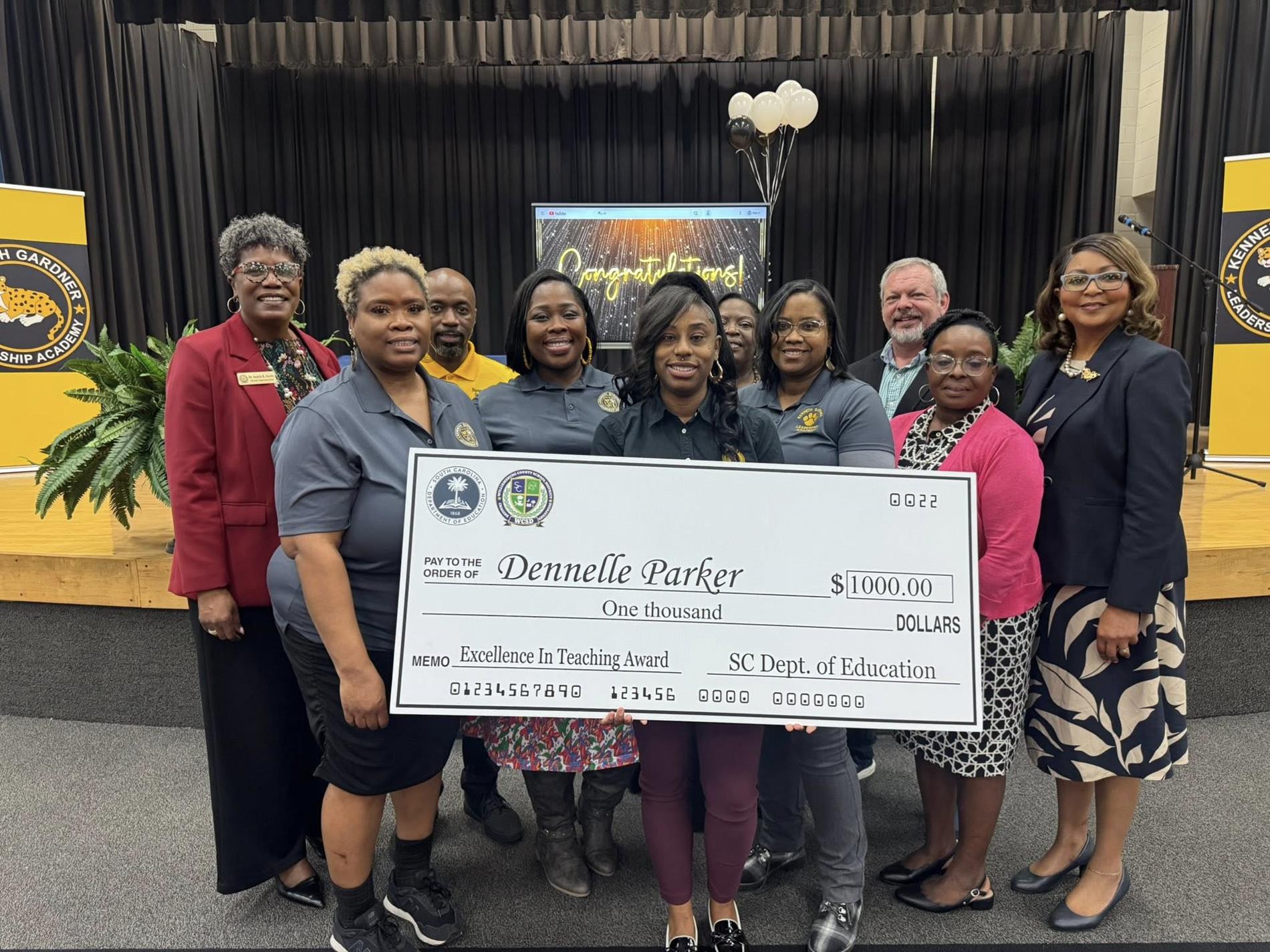 people standing  holding large check 