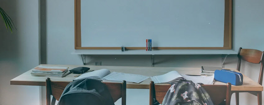 Empty desk in front of chalkboard