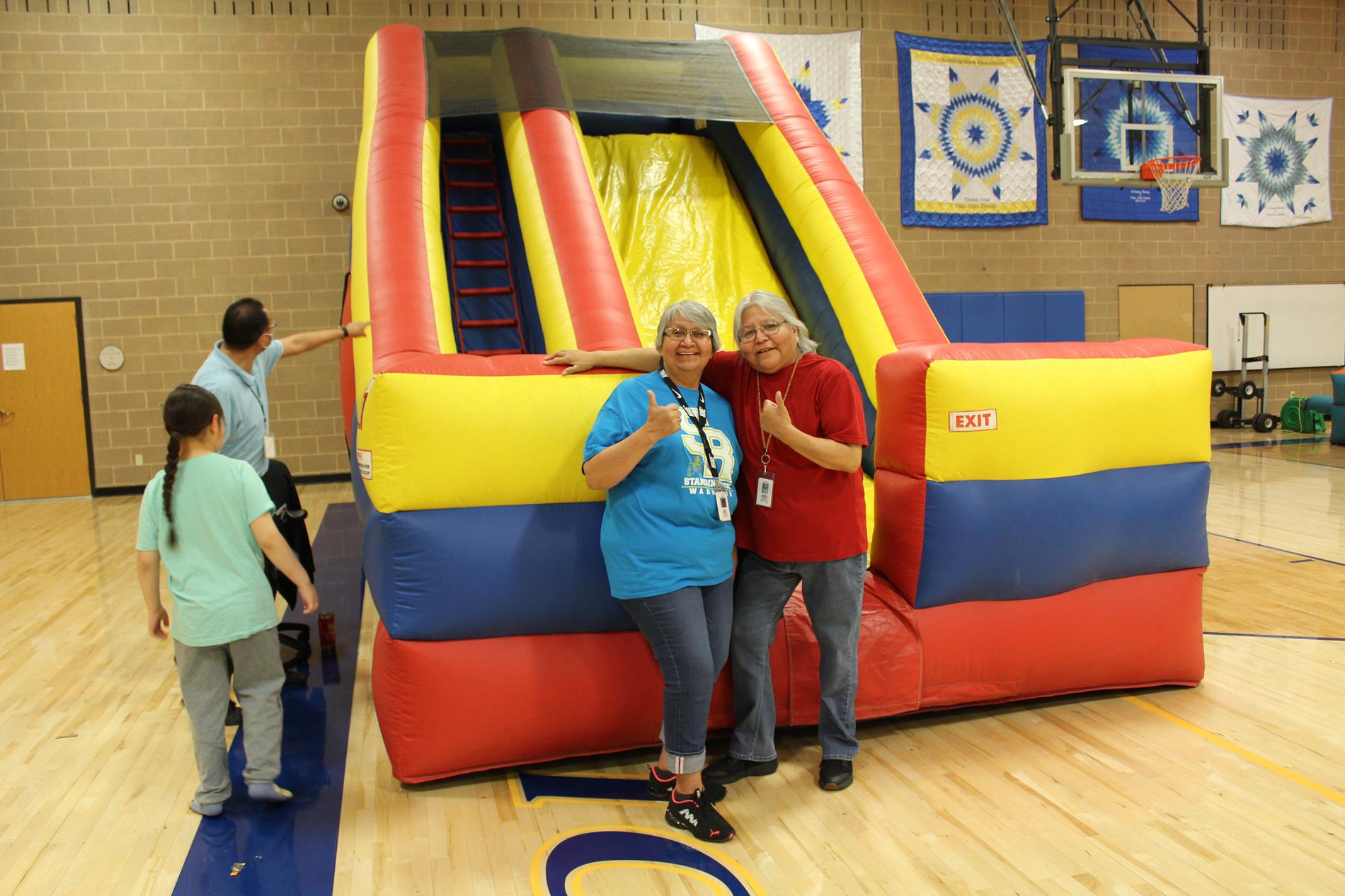 2 elementary staff giving thumbs up at the carnival