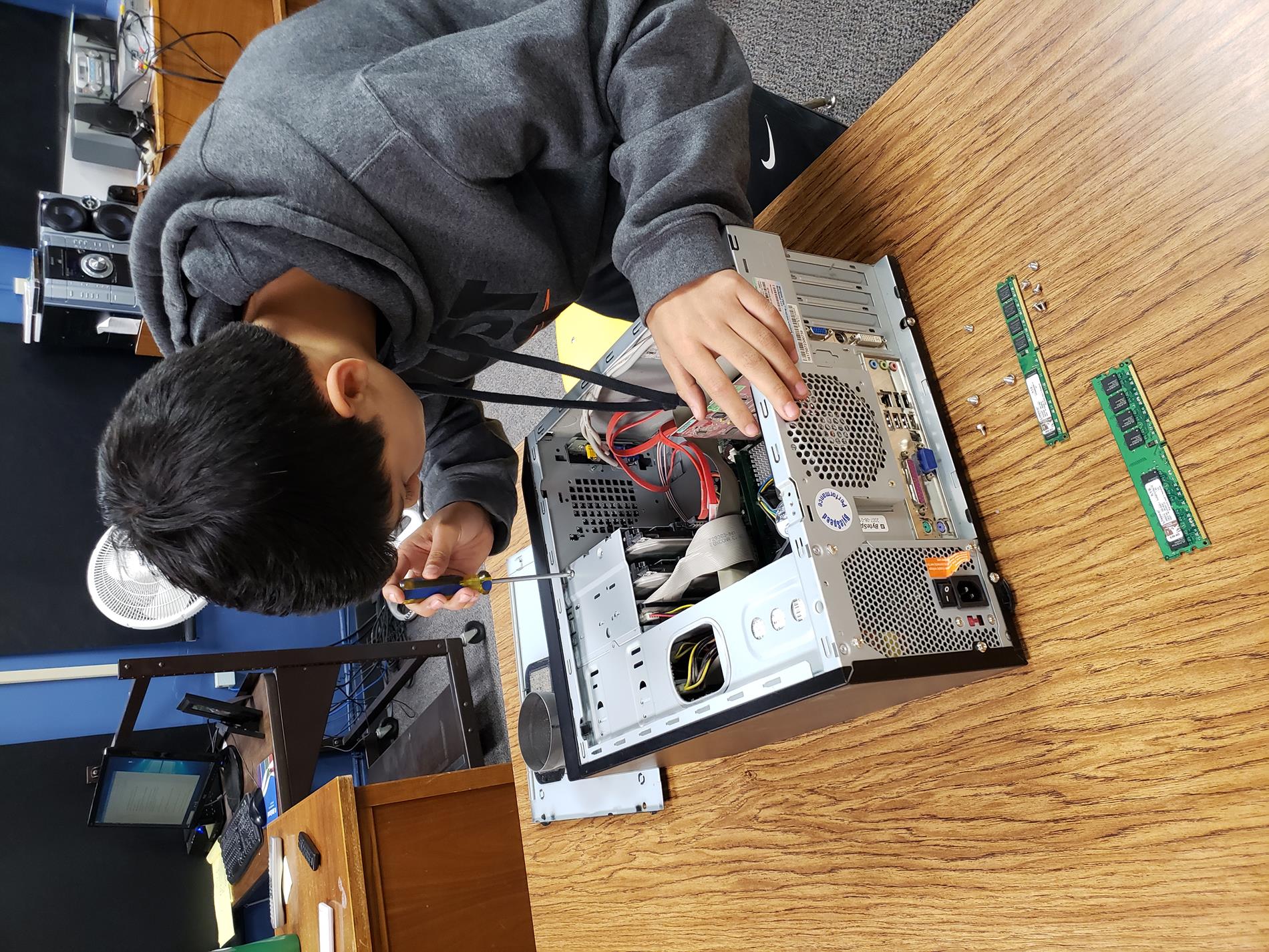 Student fixing computer hardware