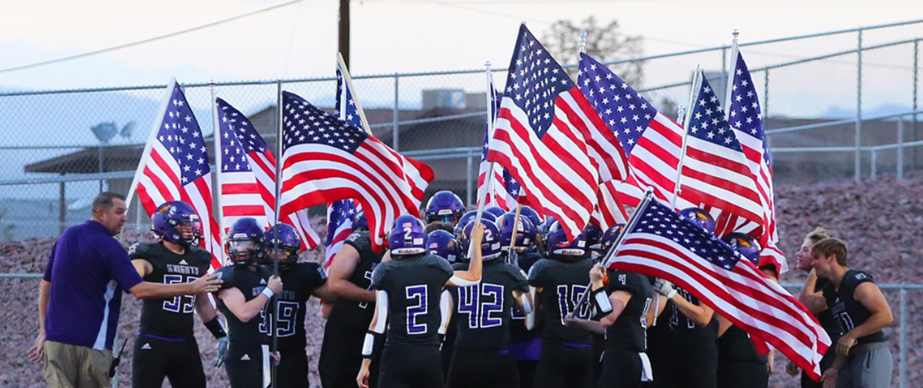 Football team huddles with American flag to honor 9-11