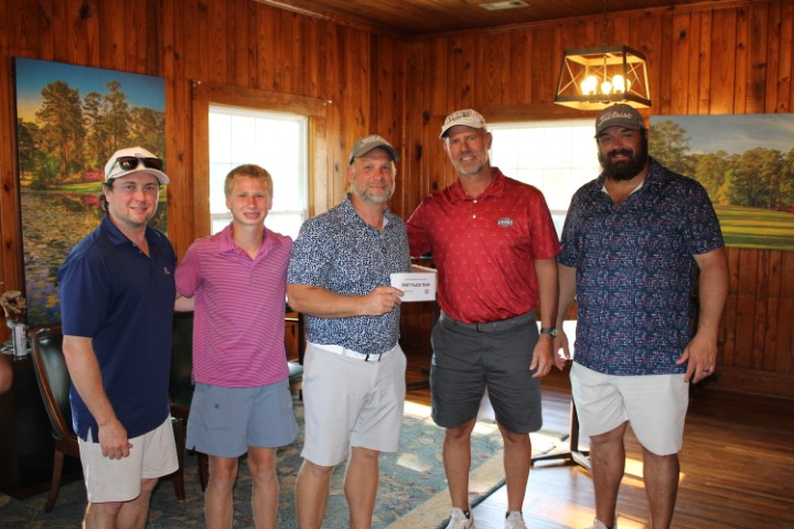 Reid State Athletic Director Brac Brady, second from right, presents Team Jubilee Pool & Patio with its first-place prize.
