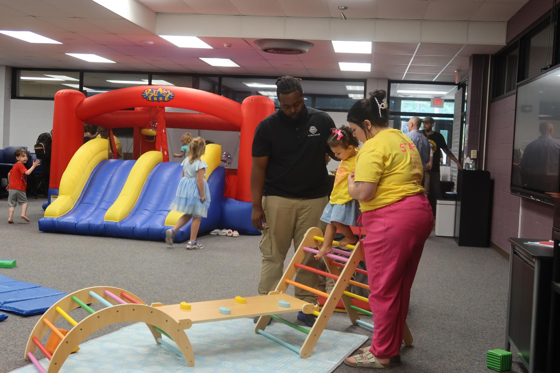 Two ROE employees help a child during SummerFEST 2026