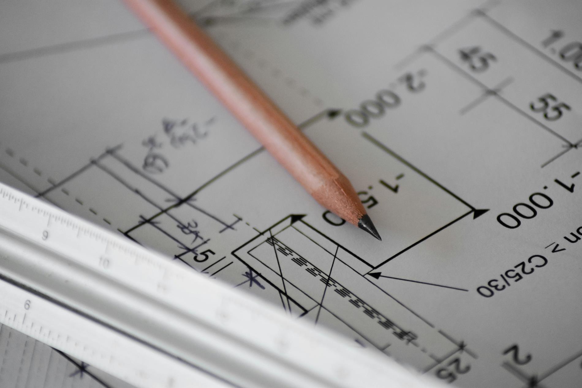 A pencil sits on a blueprint document