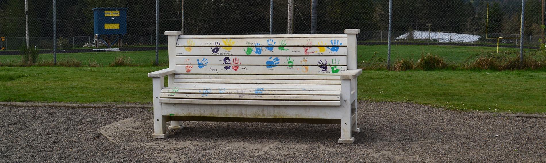 White bench with handprints on the playground