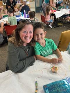 student with his grandma doing an activity for grandparents day. 