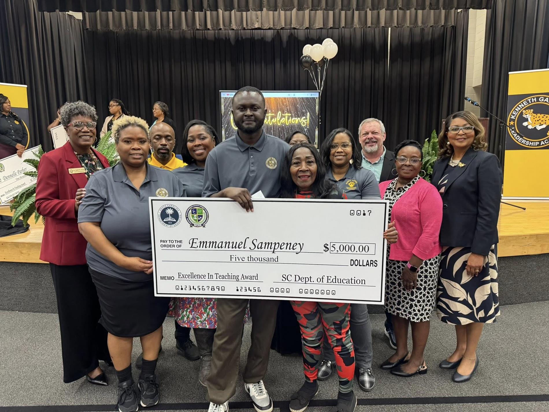 people standing holding large check 