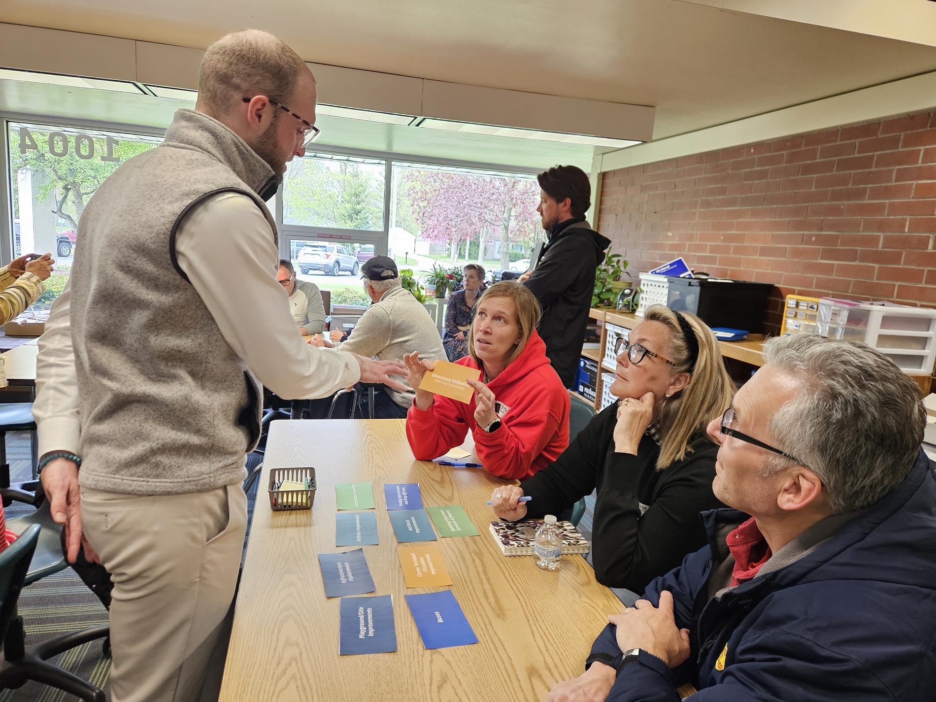 Three community members chat with GMB consultant Brady Mills about their selections for items