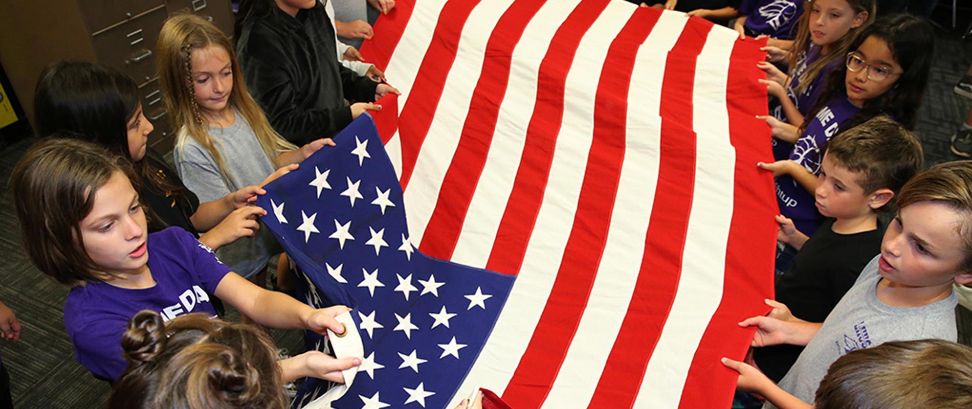 students learning to fold the American Flag during Civics lesson