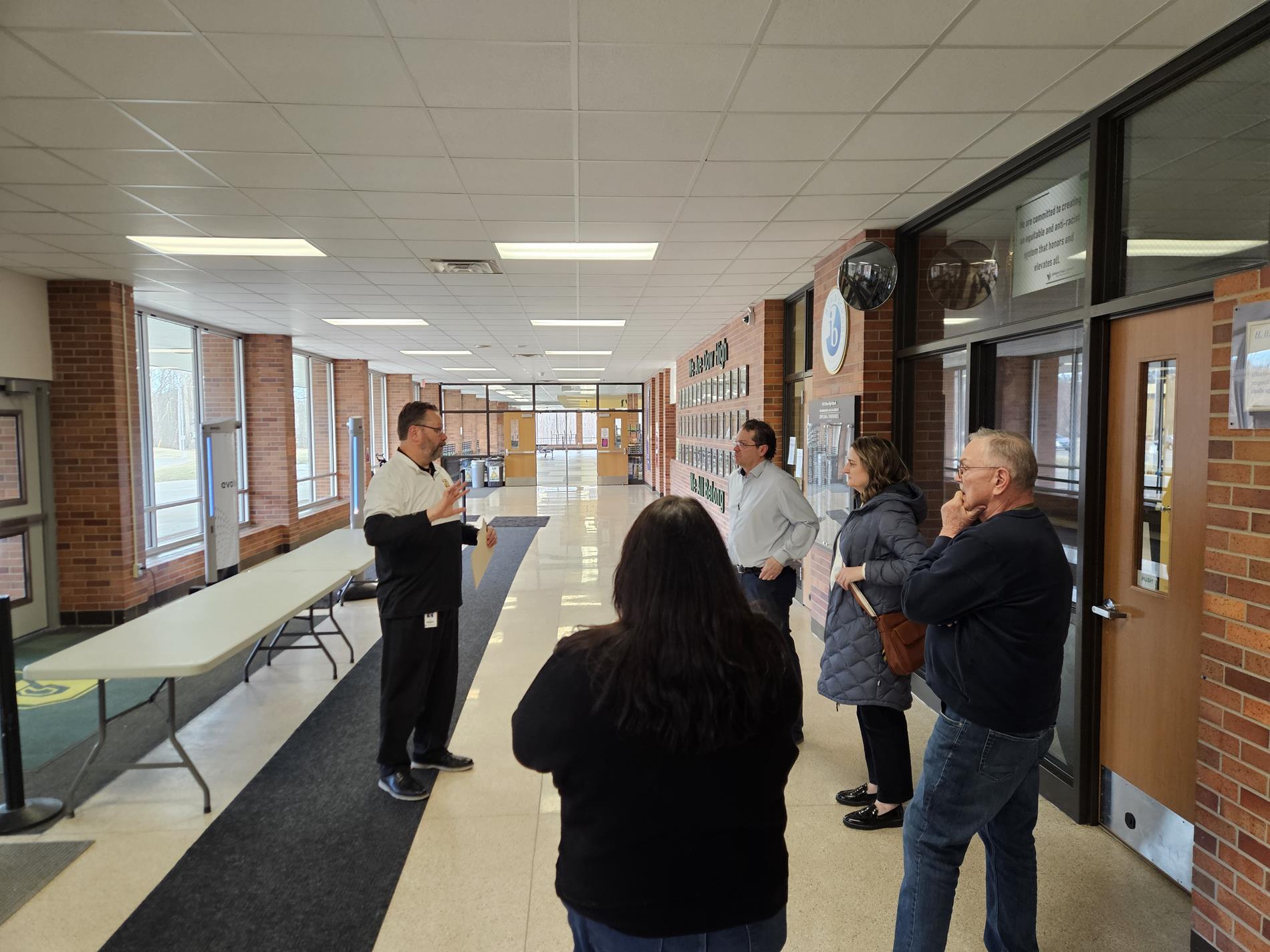 Steering Team members join Dow High Principal Scott Cochran on a tour of Dow High School in the lobby