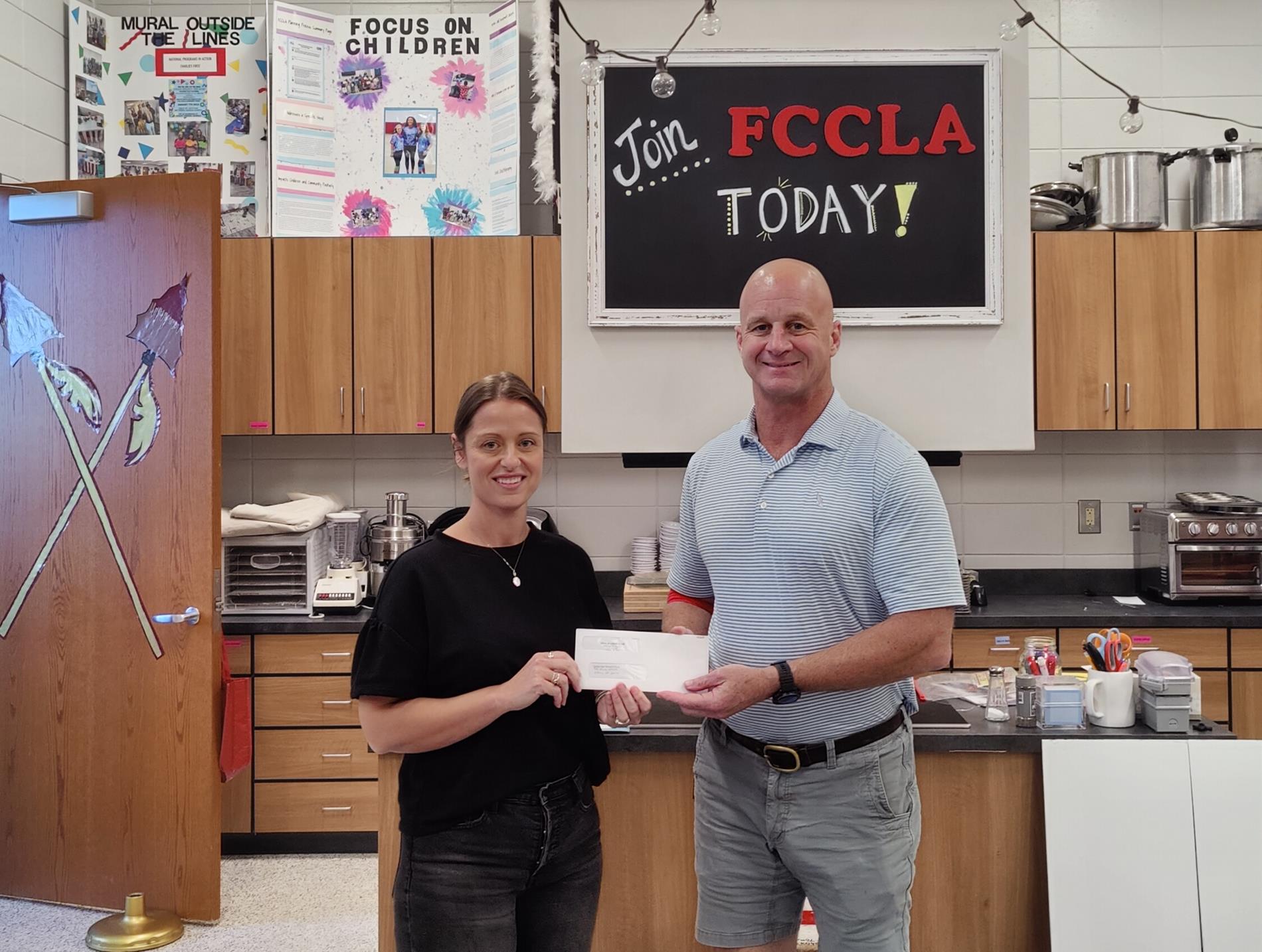 Vidalia Lions Club Member Fred Godbee presents a check for $1000.00 to FCCLA Sponsor Amanda Mosley 