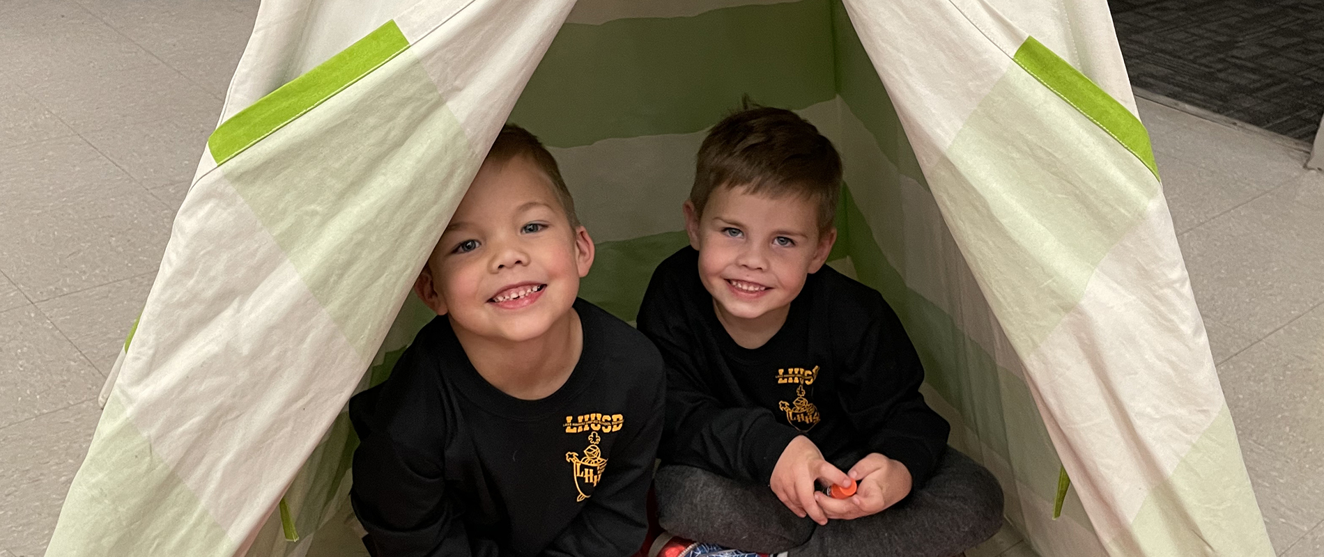 boys sit in tent at Camp Read-In event