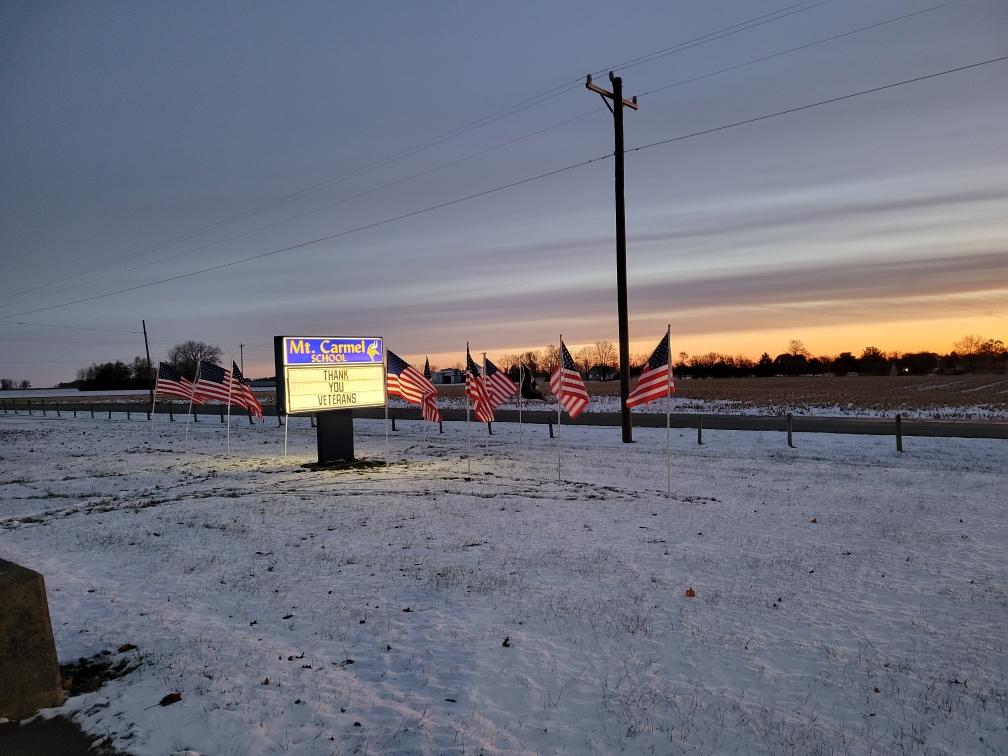 flags by the school sign