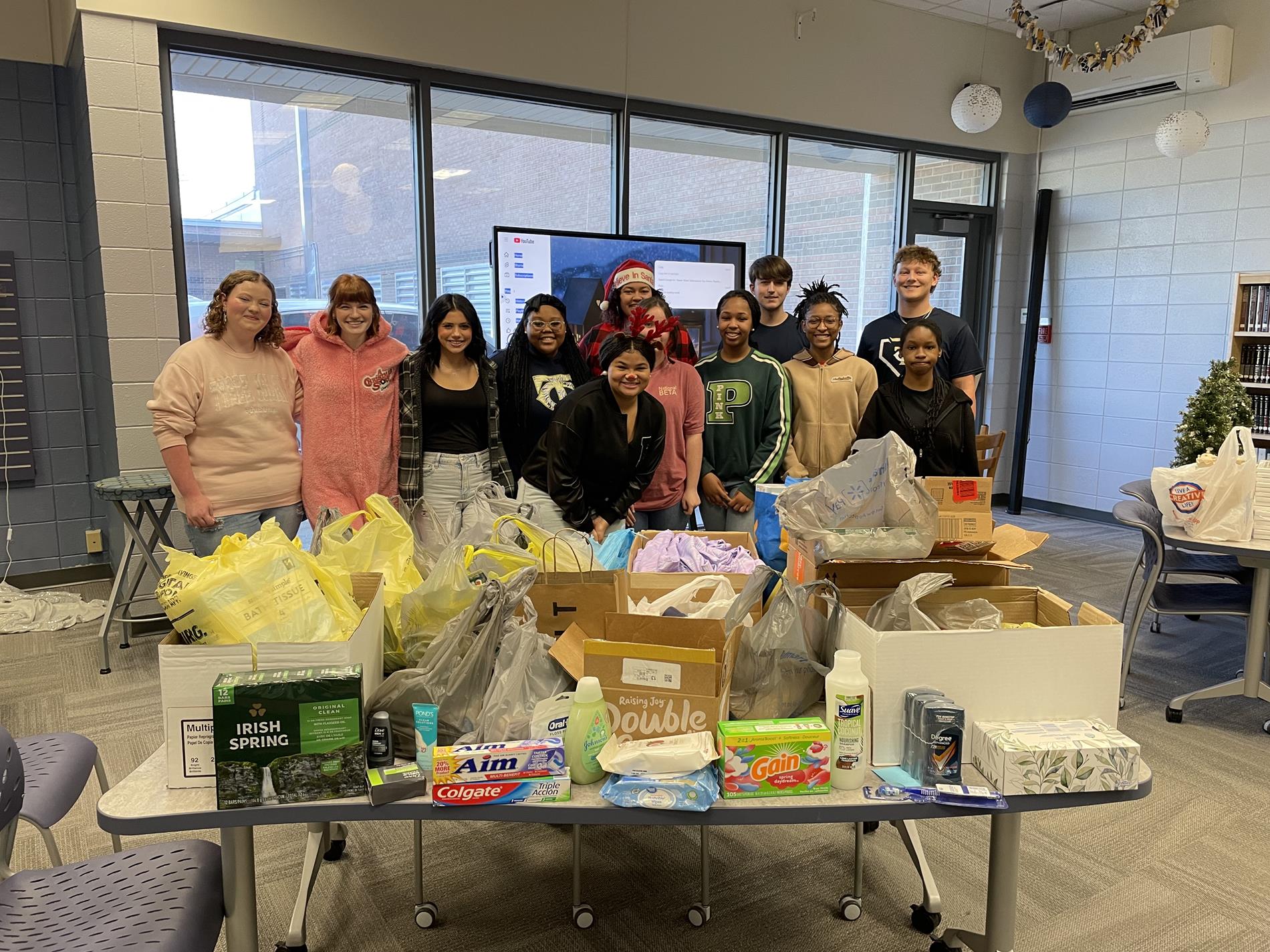 TCHS students gathered next to donated hygiene items