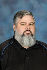 Teacher smiling against a blue background