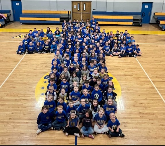 ALIS students and staff form a cross 