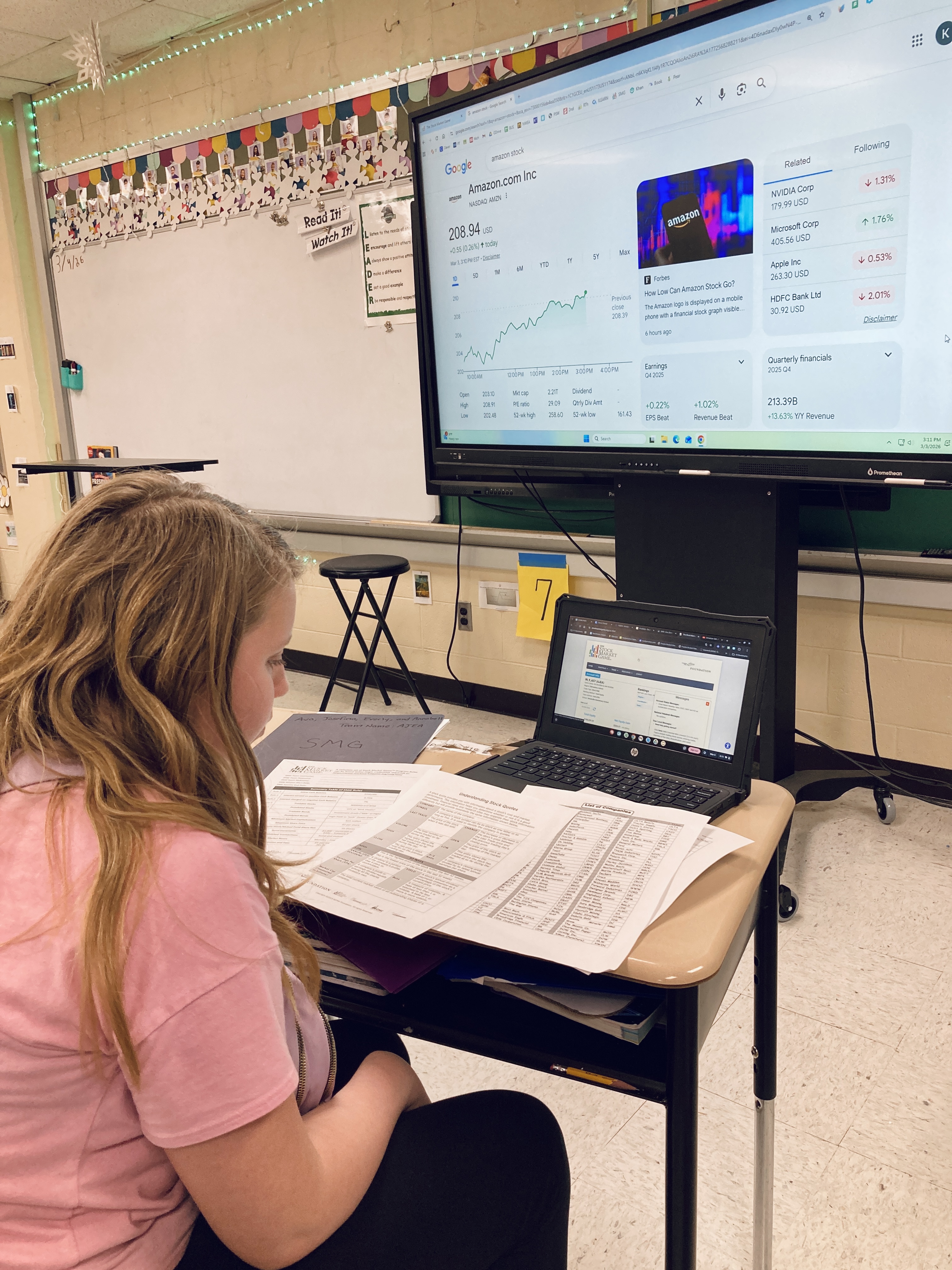 Student studying stock listings preparing to invest in "The Stock Market Game".