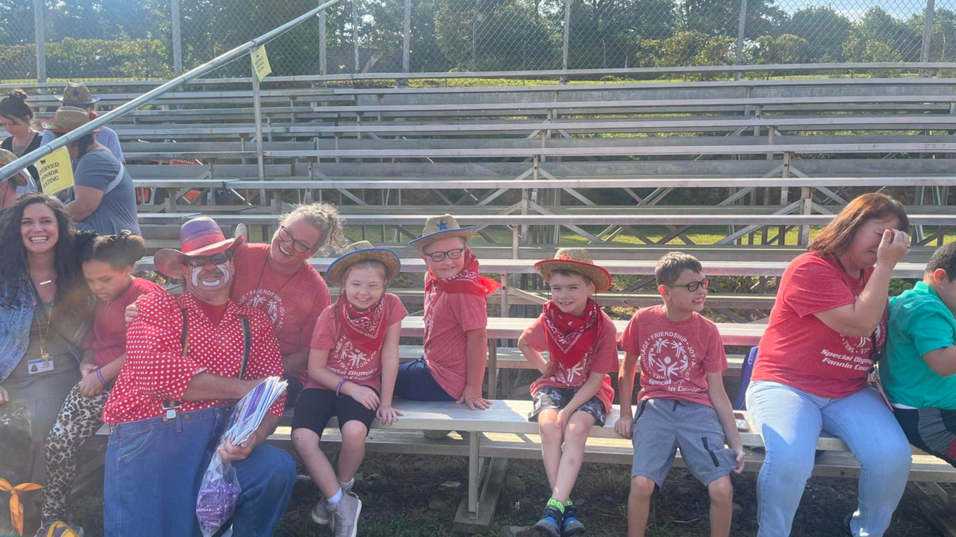 Mrs. Stout and Mrs. Bennett's students sit together on the bleachers at the rodeo