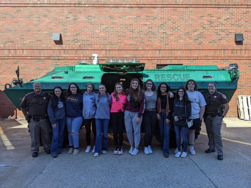 Massac Sheriff with high school students in front of armored tank