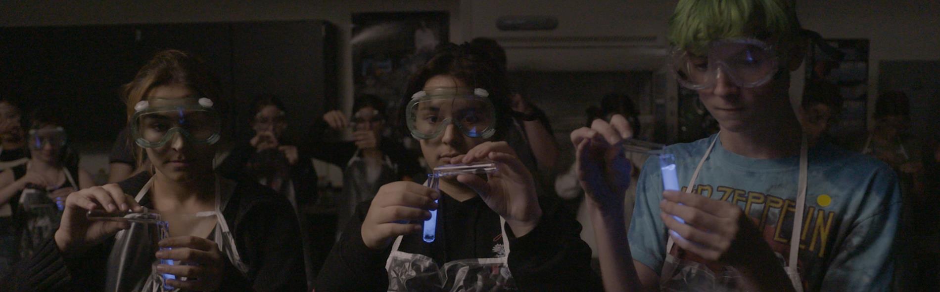 students with phosphorescent tube in chemistry lab 