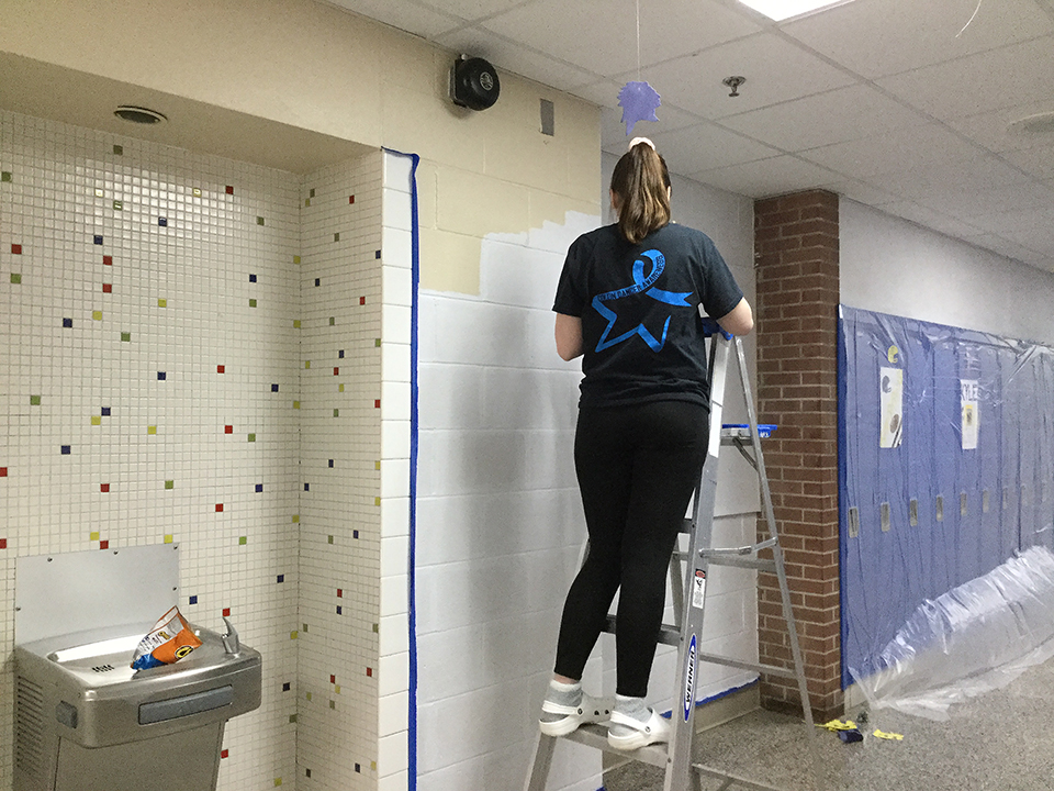 Students volunteering to help paint